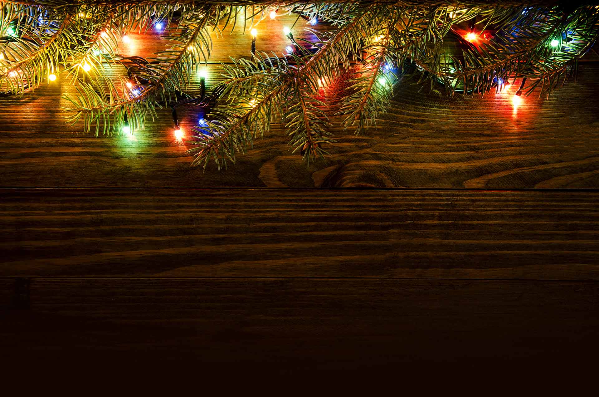 Holiday lights on a wood wall.