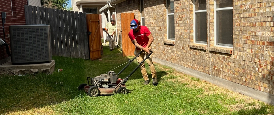 Buffalo Outdoor worker mowing lawn with a push mower in White Settlement, TX.
