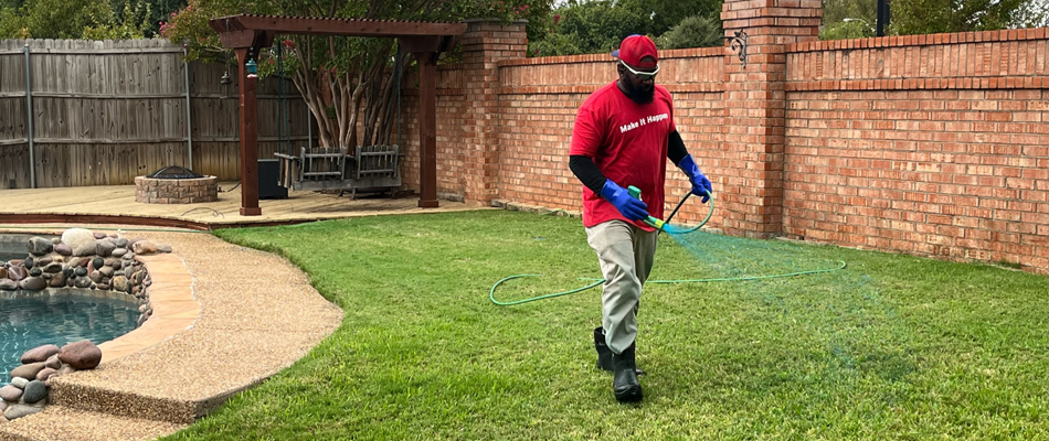 Technician applying lawn care treatment to a lawn in Bedford, TX.